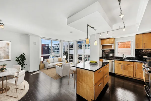 a room with stainless steel appliances granite countertop a stove and a living room view