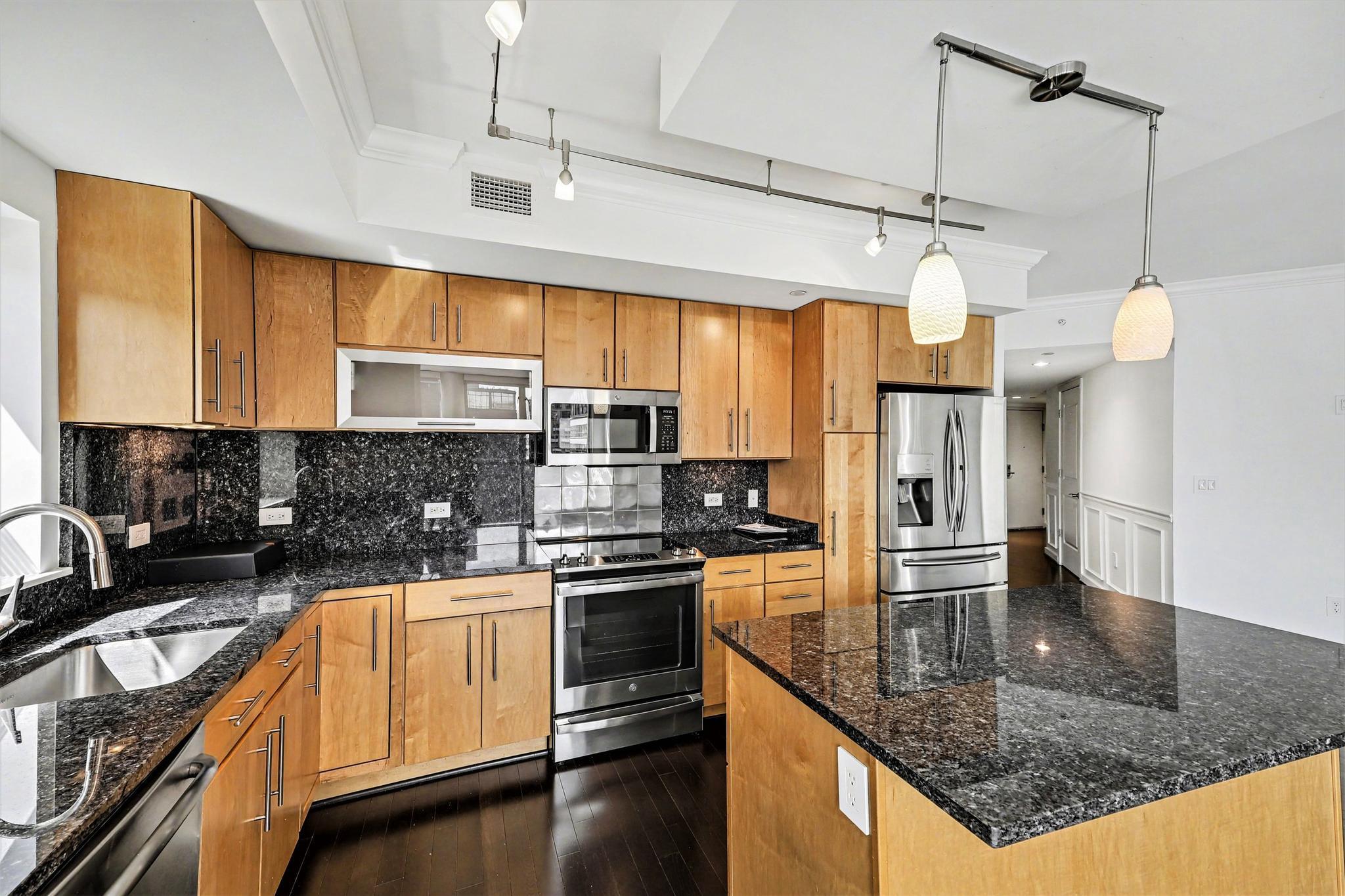 1025 First Street Southeast, Unit 906 Washington, DC 20003 - Photo 5 of 34 a kitchen with stainless steel appliances granite countertop a sink a stove counter space and cabinets