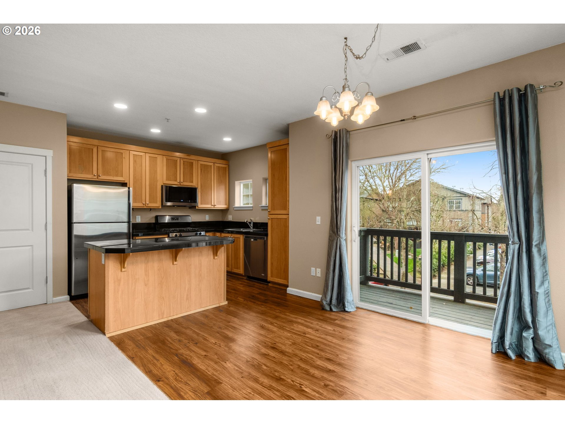 1060 Southwest 170th Avenue, Unit 202 Beaverton, OR 97003 - Photo 12 of 27 a kitchen with stainless steel appliances kitchen island granite countertop a refrigerator a stove a sink and a microwave