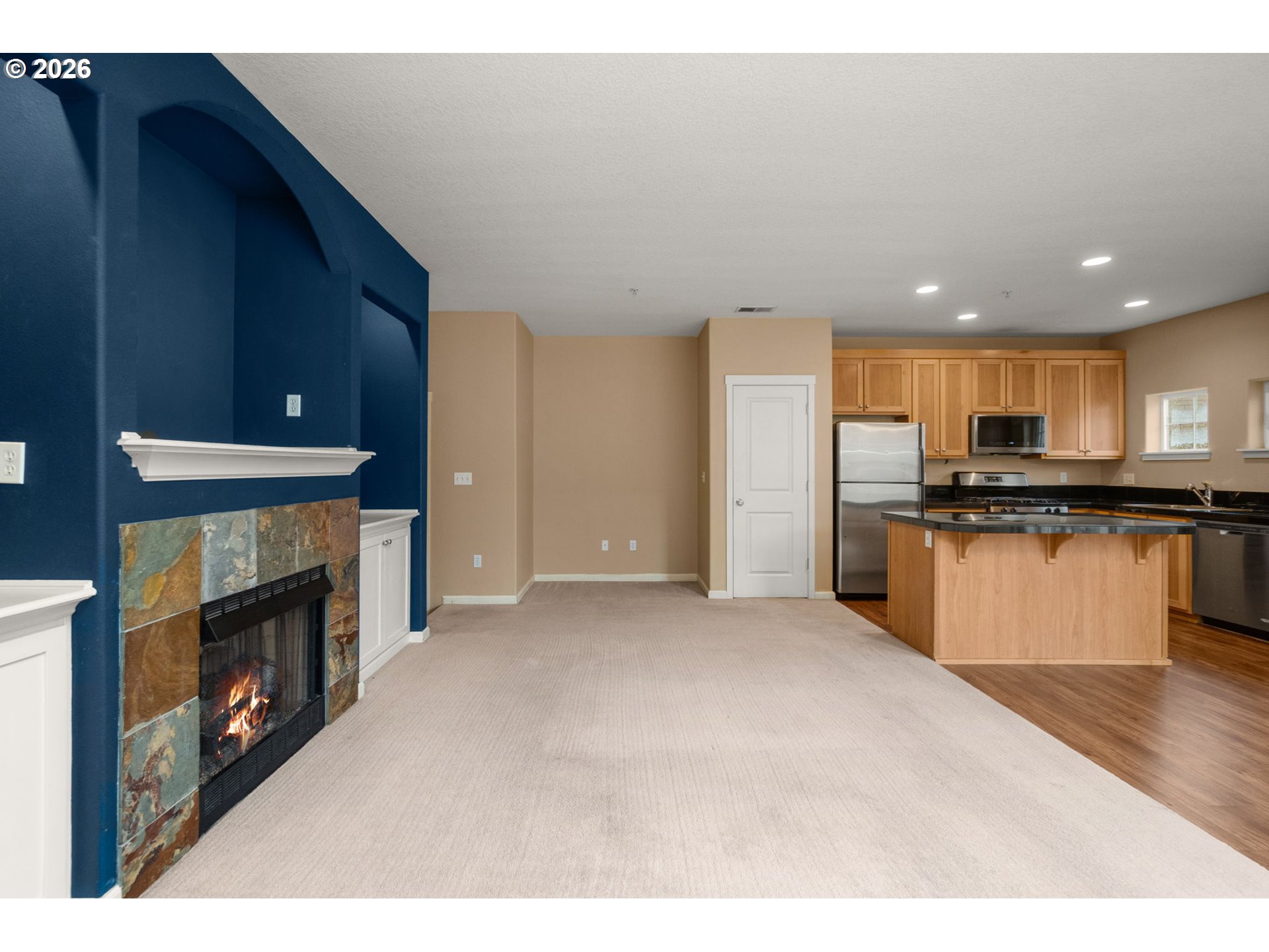 1060 Southwest 170th Avenue, Unit 202 Beaverton, OR 97003 - Photo 7 of 27 a kitchen with stainless steel appliances kitchen island granite countertop a refrigerator oven a sink and a dishwasher with wooden floor