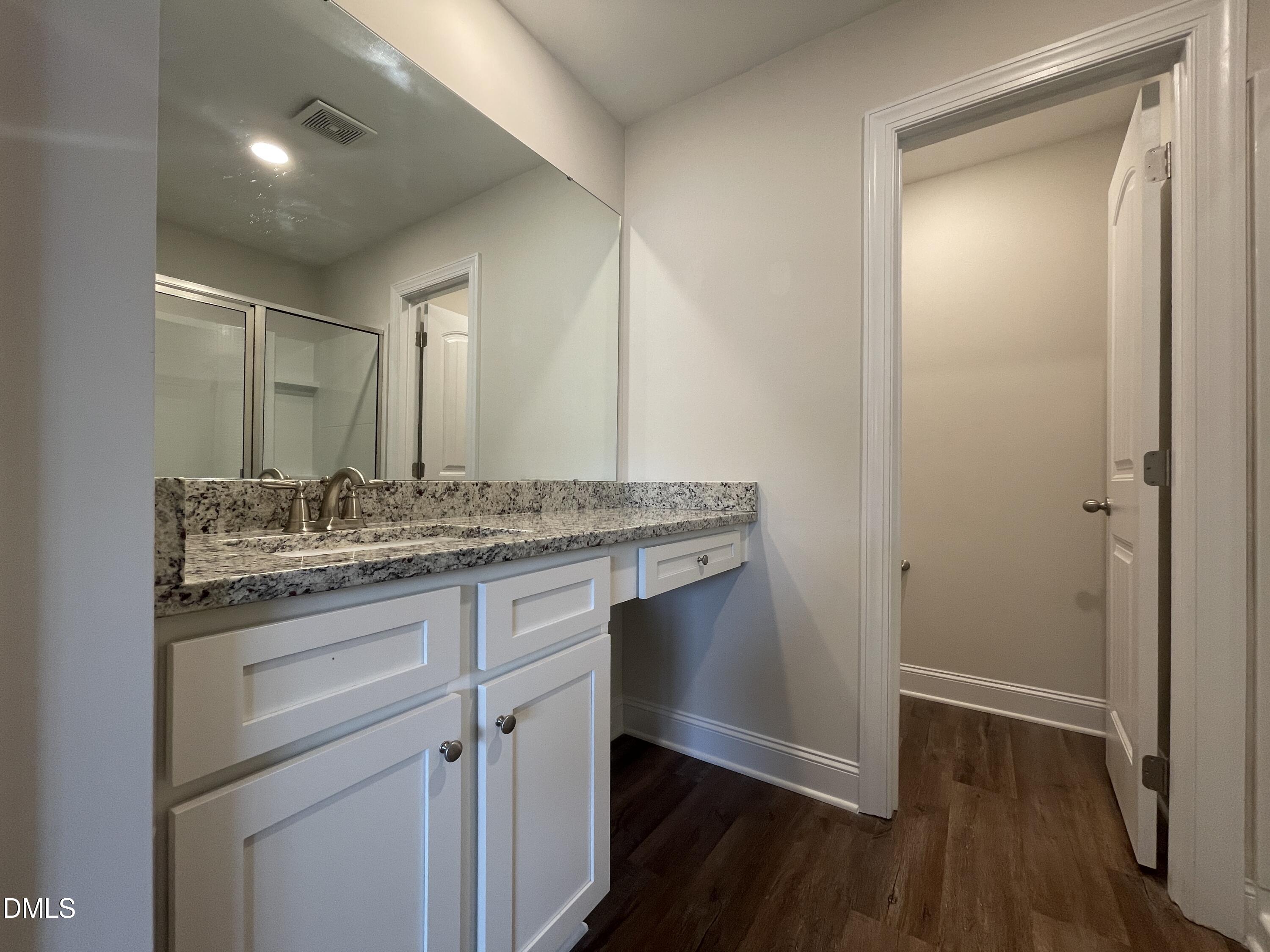 6945 Outfall Point Lane Raleigh, NC 27616 - Photo 15 of 23 a bathroom with a granite countertop sink toilet and mirror