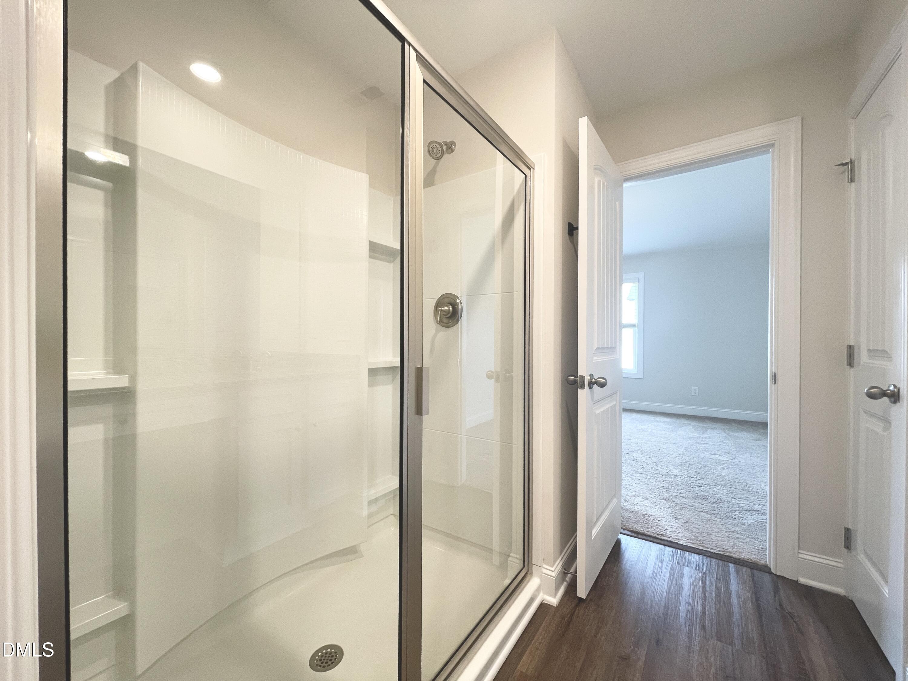 6945 Outfall Point Lane Raleigh, NC 27616 - Photo 16 of 23 a bathroom with a glass shower door and a glass door