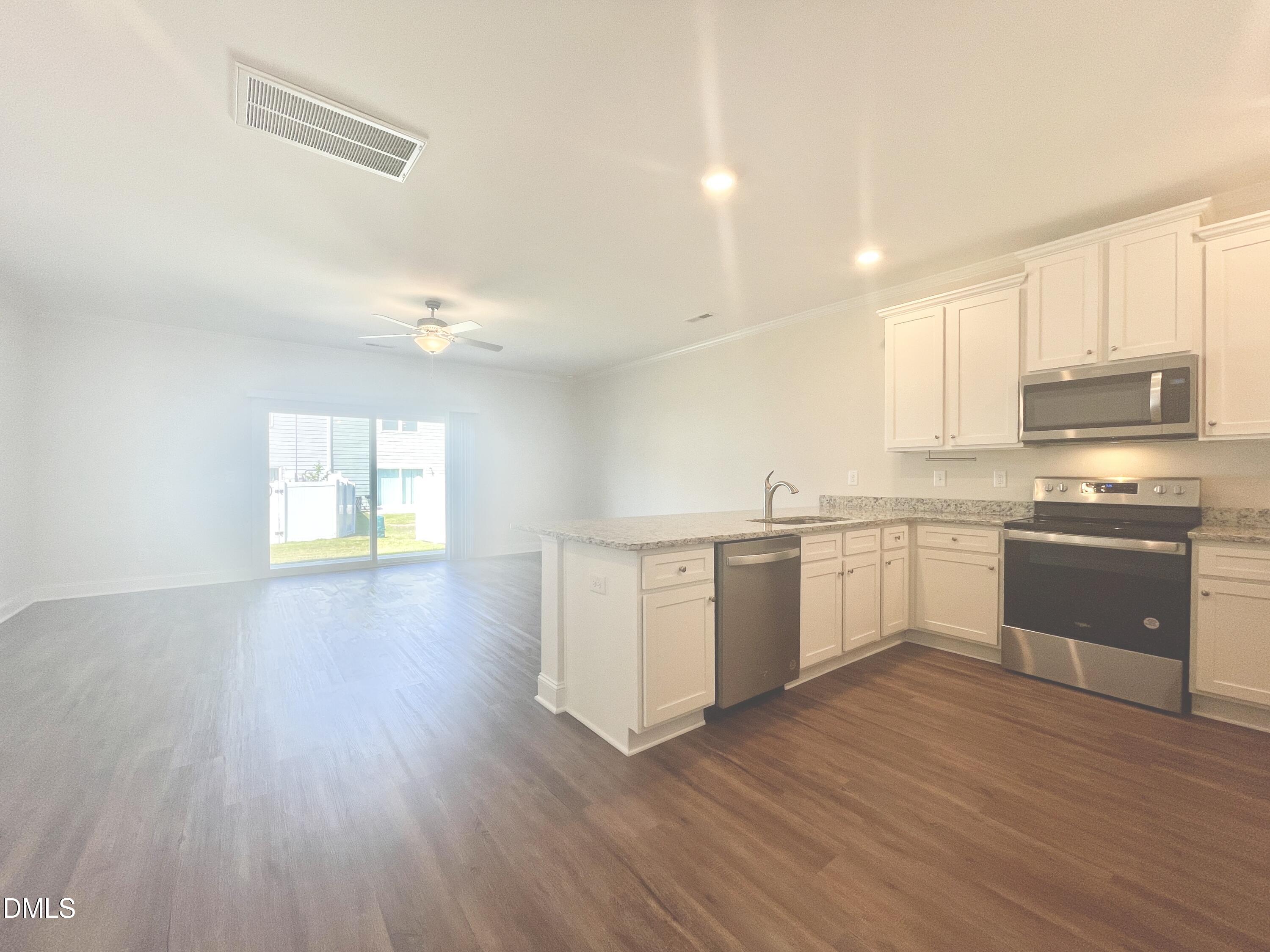 6945 Outfall Point Lane Raleigh, NC 27616 - Photo 3 of 23 a kitchen with a white cabinets and window