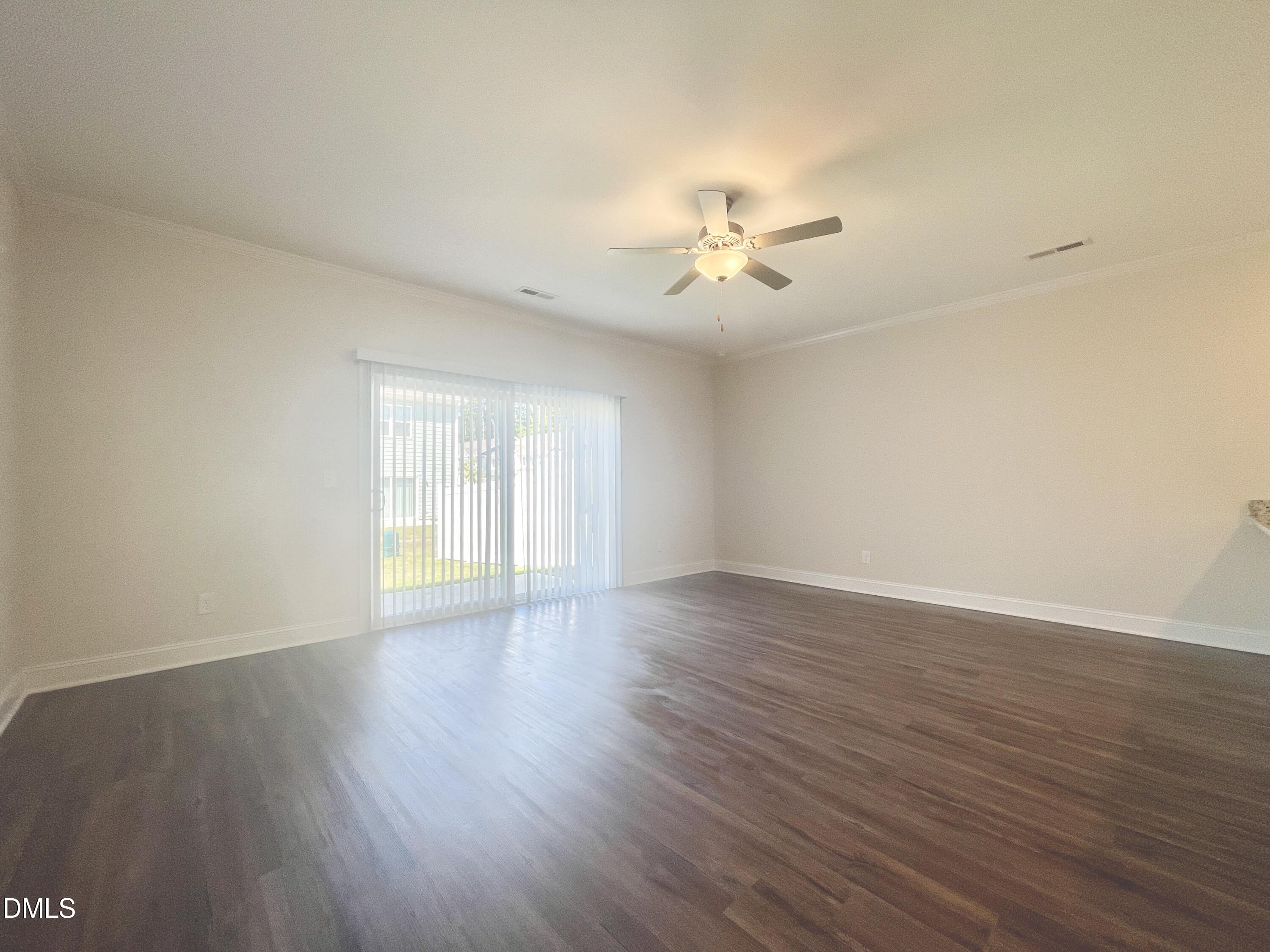 6945 Outfall Point Lane Raleigh, NC 27616 - Photo 6 of 23 a view of an empty room with a window and wooden floor