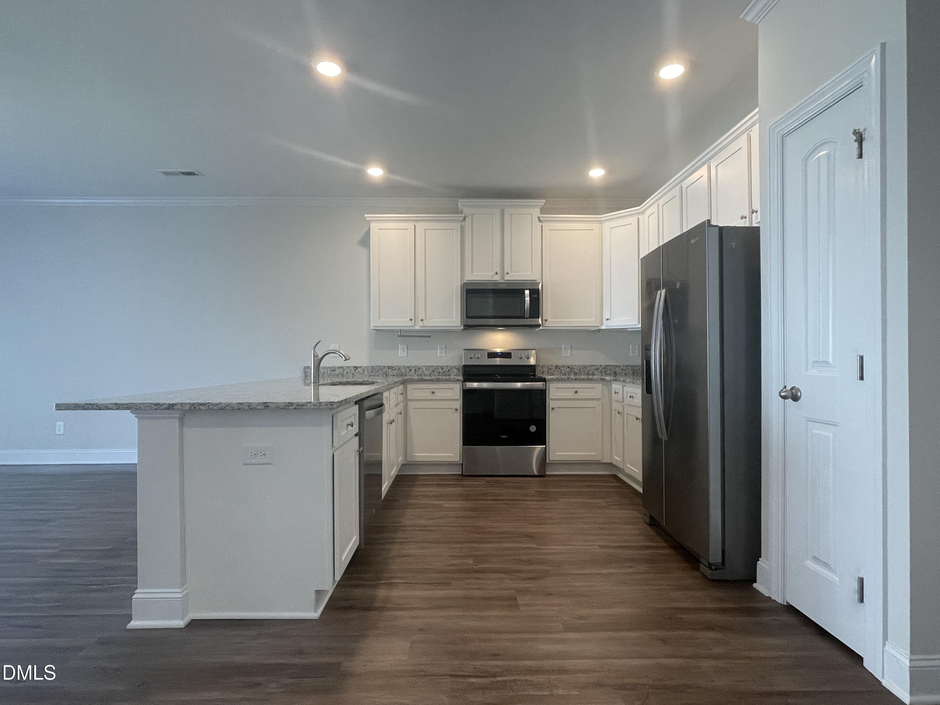 6945 Outfall Point Lane Raleigh, NC 27616 - Photo 8 of 23 a kitchen with stainless steel appliances granite countertop a refrigerator stove and oven