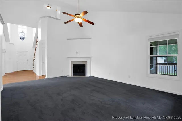 an empty room with windows and fireplace