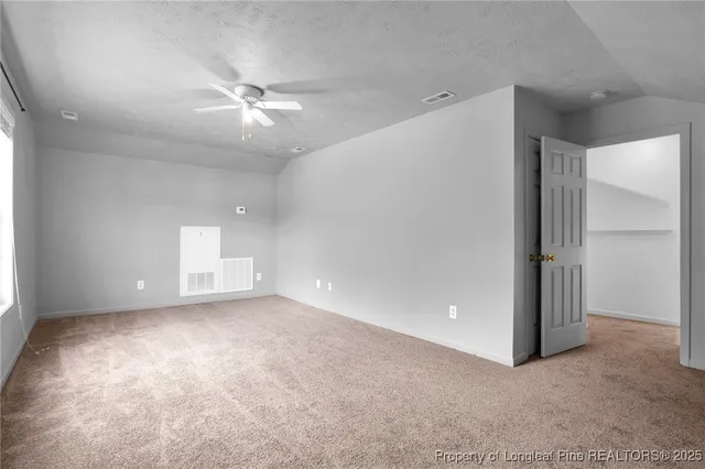 an empty room with closet and a ceiling fan