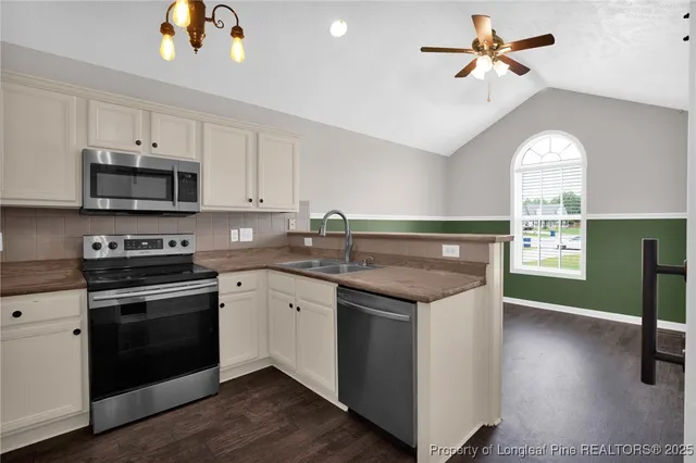 a kitchen with granite countertop a stove a sink and a microwave