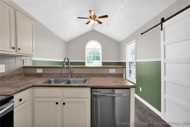 a kitchen with a sink a chandelier and a refrigerator