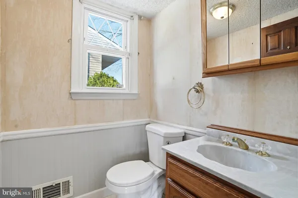 a bathroom with a toilet a sink and mirror