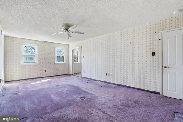 an empty room with a ceiling fan and a window