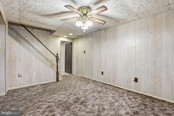 a view of a livingroom with a chandelier fan and a window