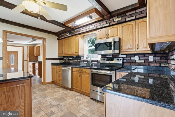 a kitchen with granite countertop a stove and a microwave