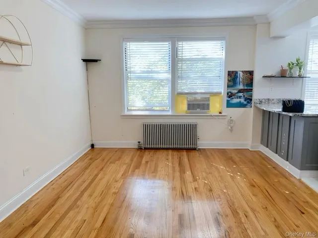 a view of a kitchen with wooden floor and a window