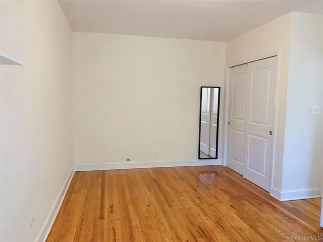 an empty room with wooden floor and closet