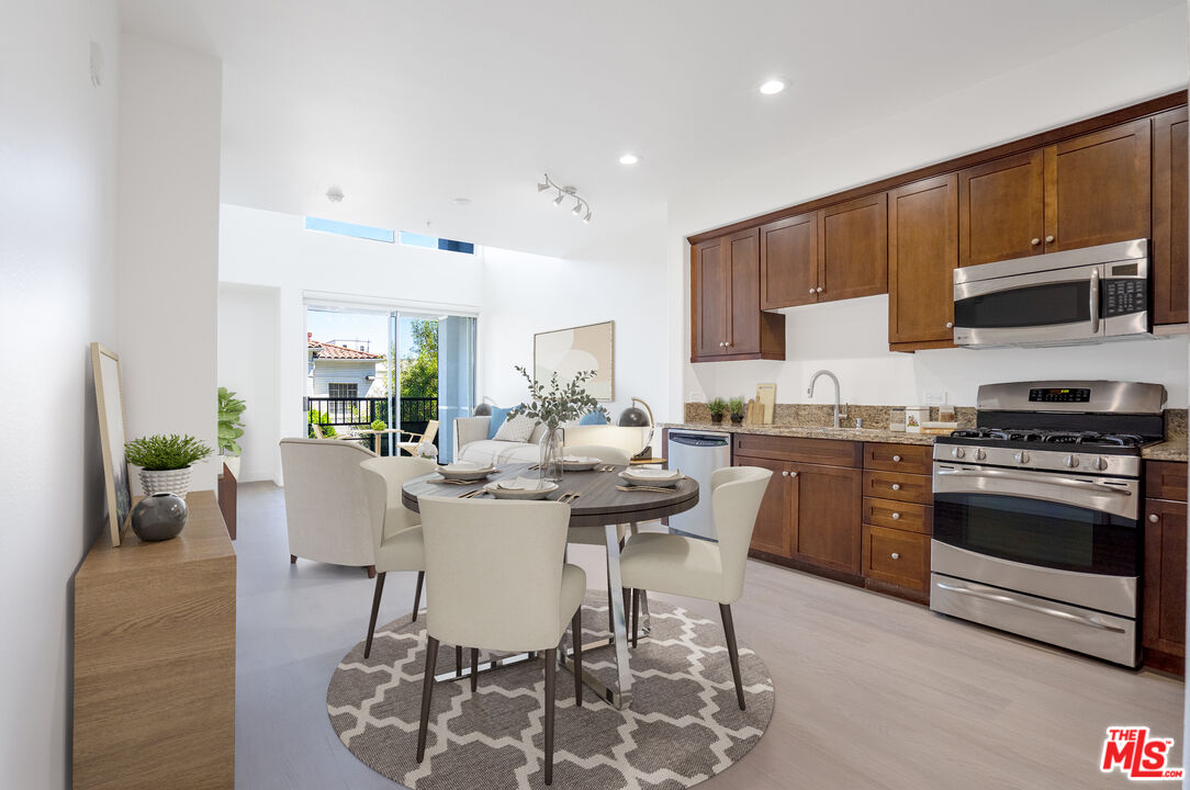 629 Traction Avenue, Unit 239 Los Angeles, CA 90013 - Photo 2 of 44 a kitchen with stainless steel appliances kitchen island granite countertop a stove a sink a dining table and chairs