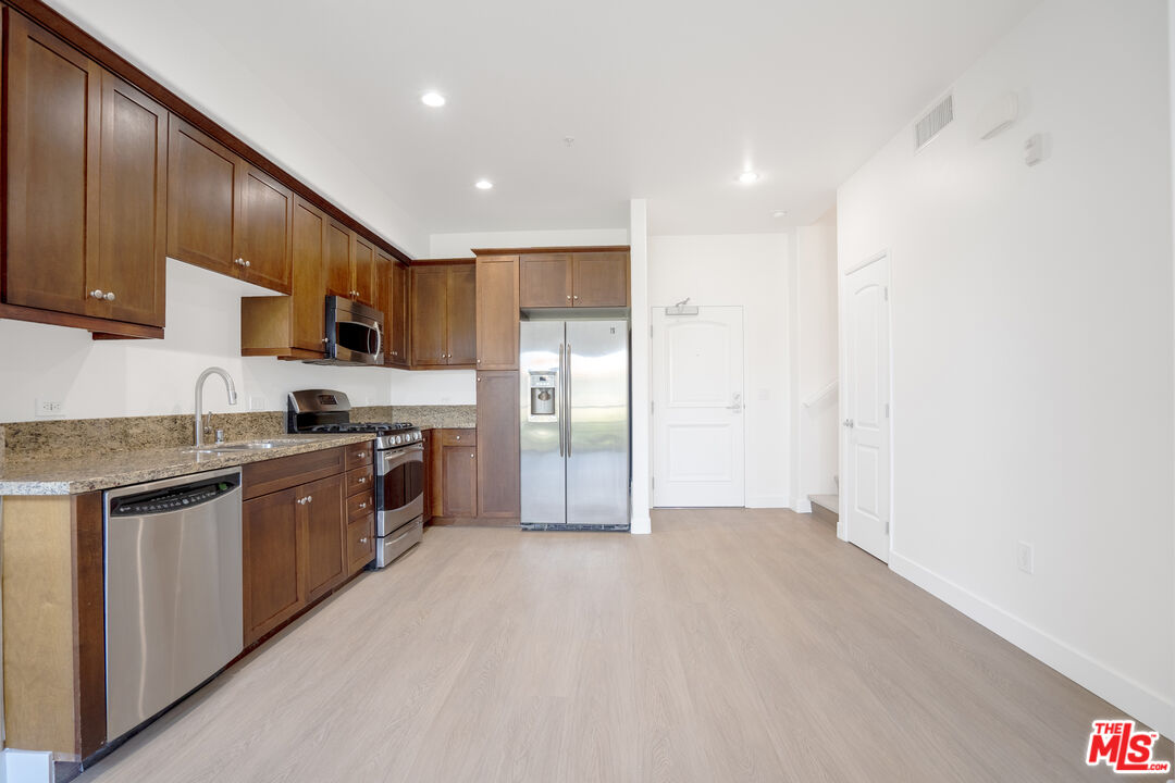 629 Traction Avenue, Unit 239 Los Angeles, CA 90013 - Photo 6 of 44 a large kitchen with stainless steel appliances granite countertop a refrigerator and a stove top oven