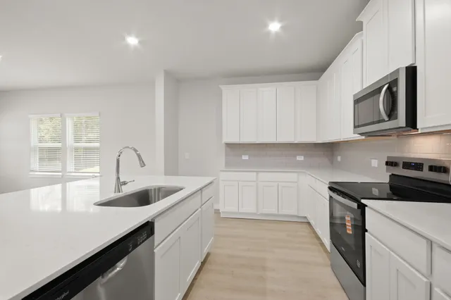 a kitchen with stainless steel appliances granite countertop a sink and stove top oven