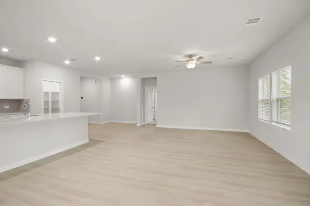 a view of an empty room with a kitchen