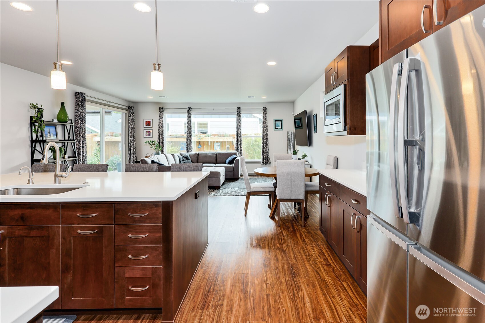 90 Village Green Sequim, WA 98382 - Photo 14 of 40 a kitchen with stainless steel appliances granite countertop a refrigerator a sink dishwasher a stove and white countertops with wooden floor