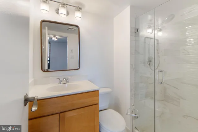 a bathroom with a toilet sink shower and mirror