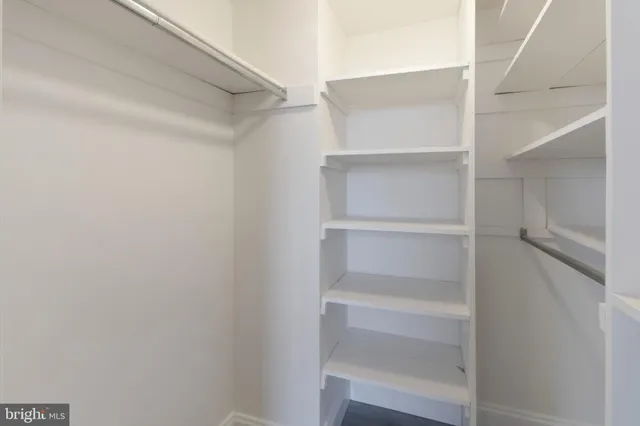 a view of walk in closet with empty racks