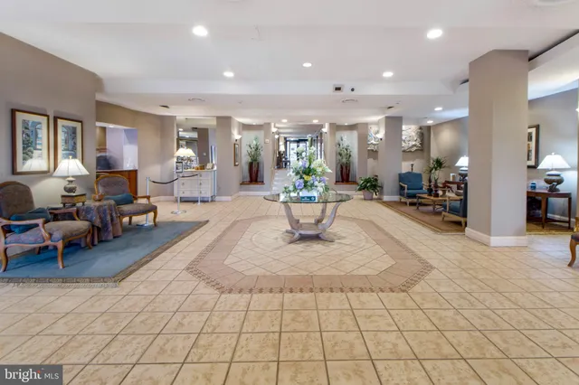 a living room with furniture and a dining table with kitchen view