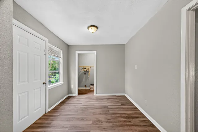 a view of a hallway with wooden floor and windows