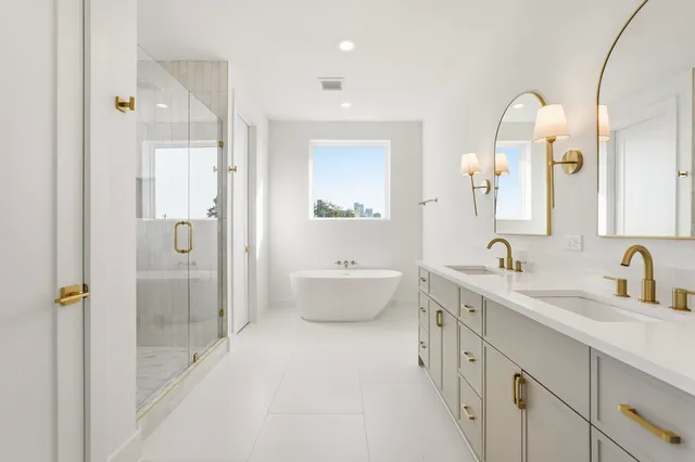 a bathroom with a double vanity sink mirror and shower