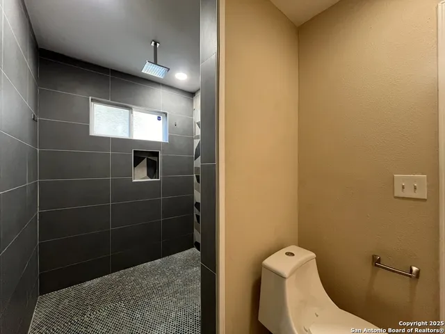 a bathroom with a tub shower vanity and a sink