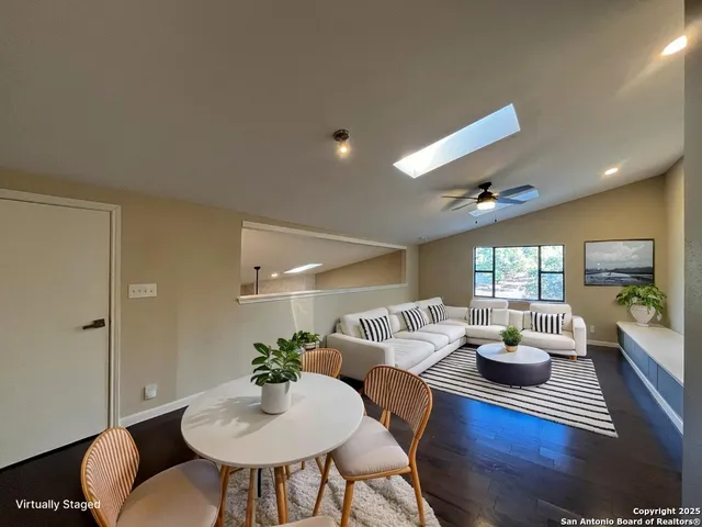 a view of an empty room with wooden floor fireplace and a window