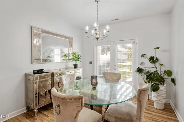 a dining room with furniture potted plants and wooden floor