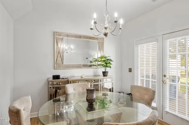 a dining room with furniture potted plants and wooden floor