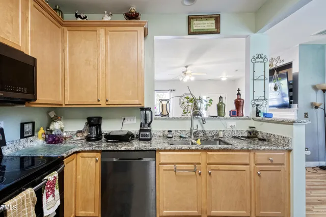 a kitchen with stainless steel appliances granite countertop a refrigerator stove and sink