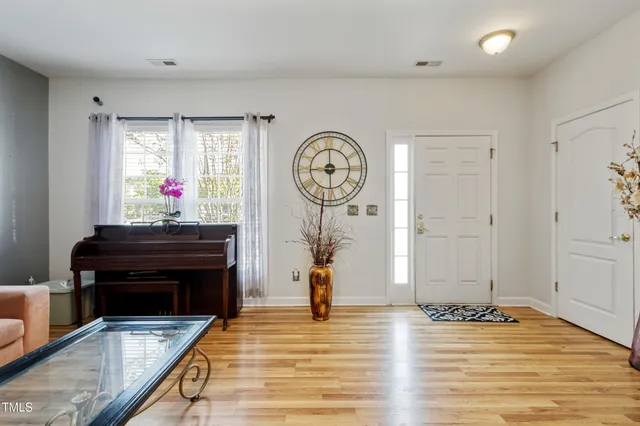 a view of a hallway with wooden floor and a potted plant