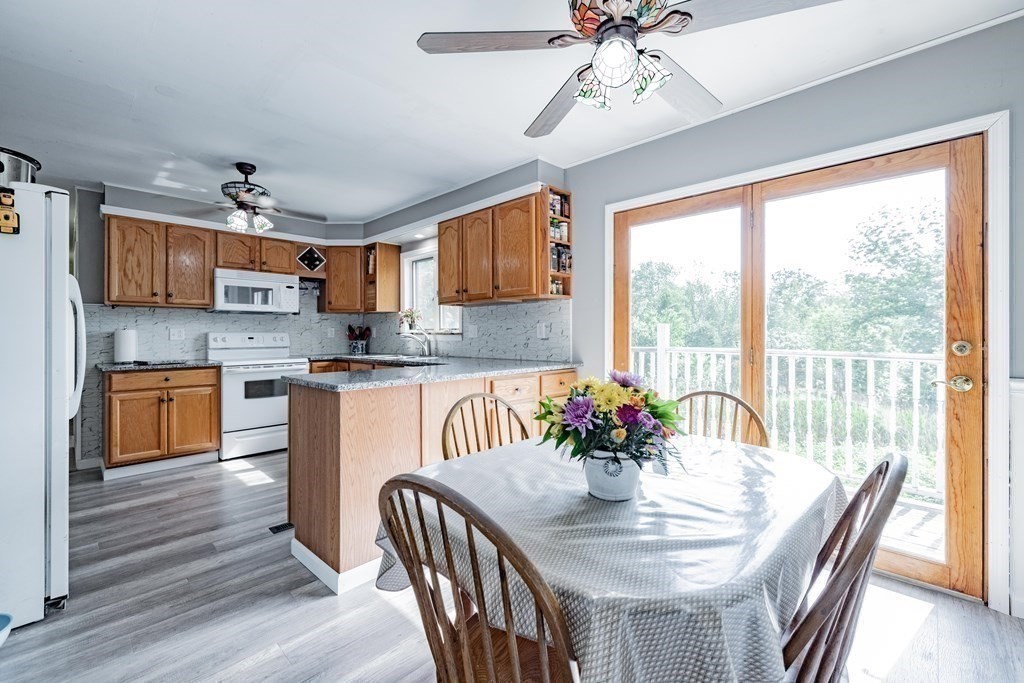 146 Bromley Road Chester, MA 01050 - Photo 12 of 40 a kitchen with stainless steel appliances granite countertop a stove a sink dishwasher a dining table and chairs with wooden floor