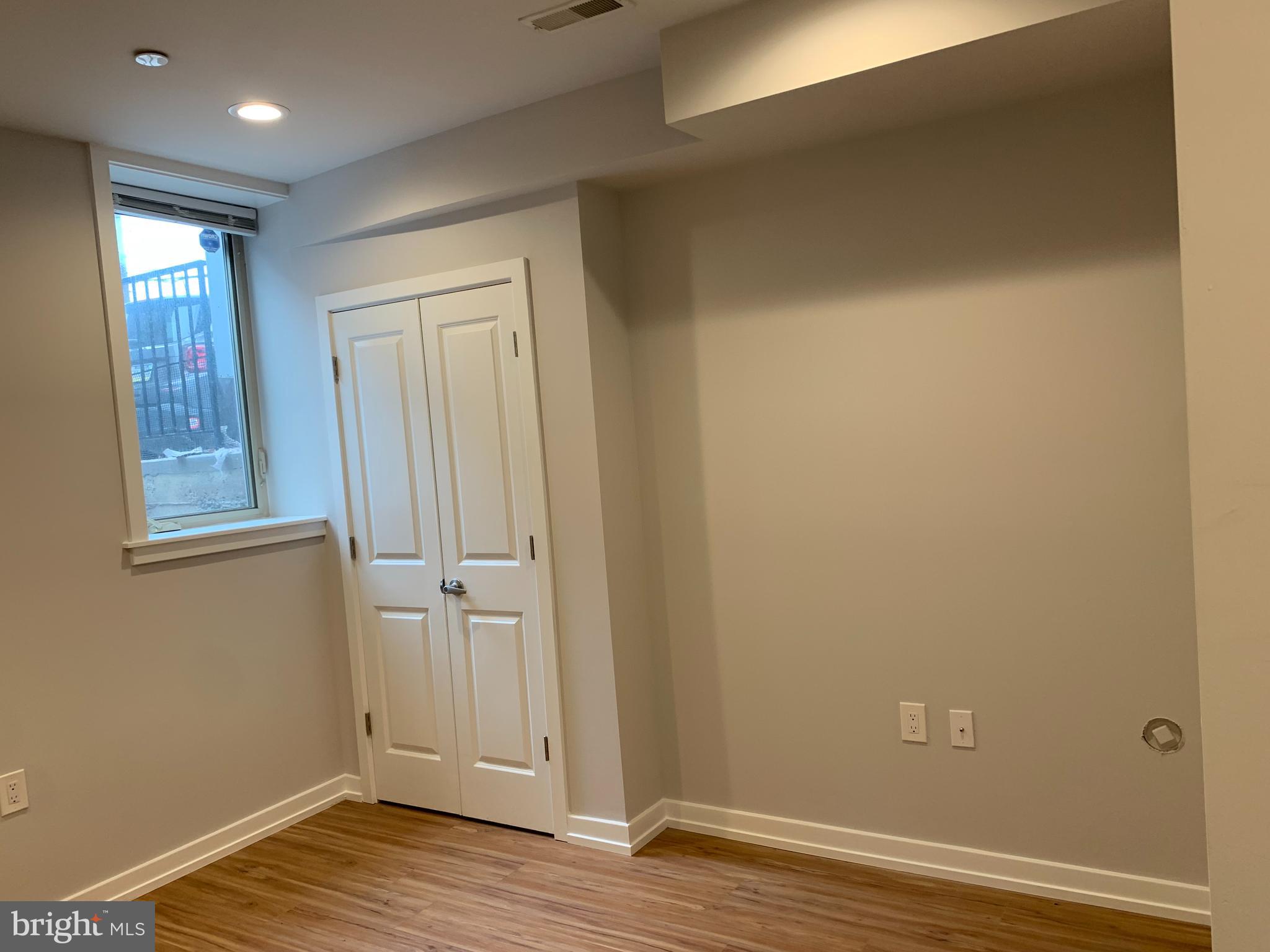1268 South 27th Street, Unit 1 Philadelphia, PA 19146 - Photo 14 of 26 an empty room with wooden floor and windows