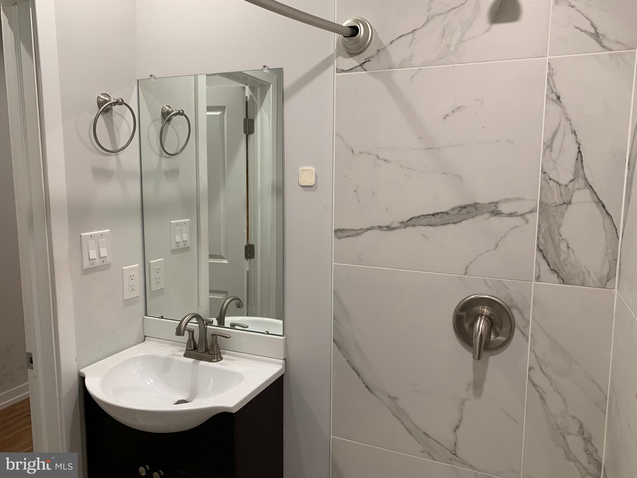 1268 South 27th Street, Unit 1 Philadelphia, PA 19146 - Photo 16 of 26 a bathroom with a sink mirror and shower