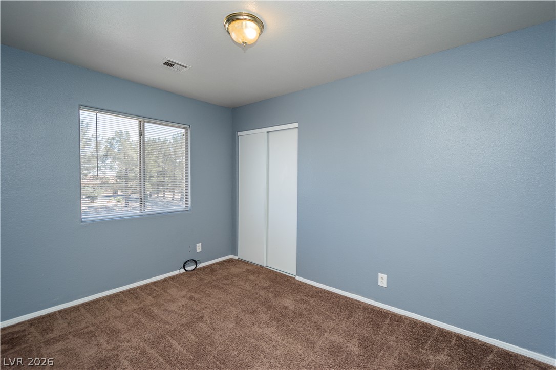 1444 Star Road Pahrump, NV 89048 - Photo 18 of 37 A spacious secondary bedroom features soft carpeting and built-in closet storage.