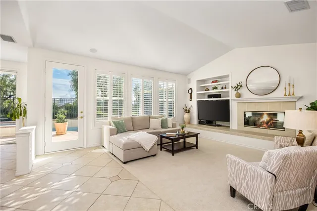 a living room with furniture a fireplace and a large window