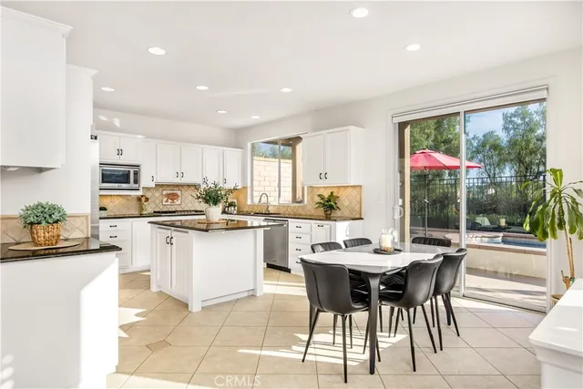 a kitchen with a dining table chairs and white appliances