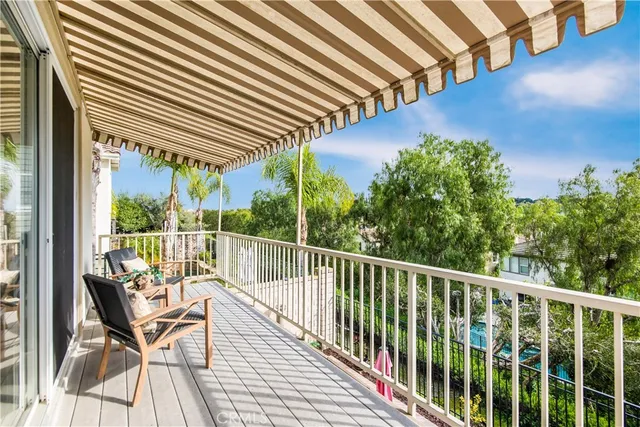 a view of a balcony with chairs and wooden floor