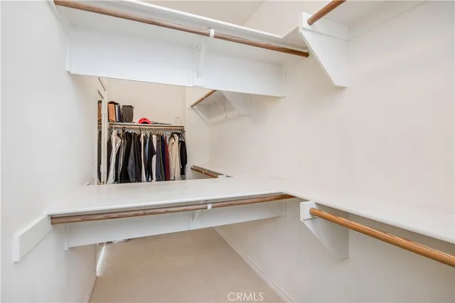 a view of walk in closet with clothes and shoes
