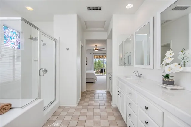 a bathroom with a double vanity sink a large mirror a bathtub and shower