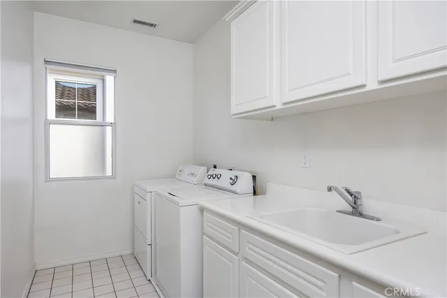 a utility room with sink dryer and washer