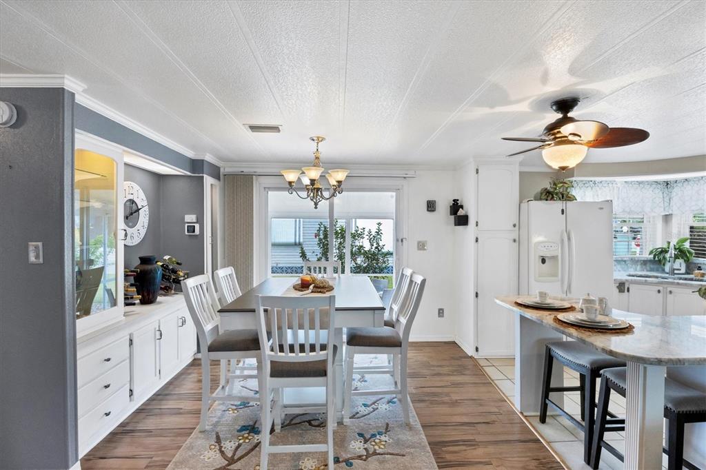 10303 Burnt Store Road, Unit 5 Punta Gorda, FL 33950 - Photo 14 of 49 a view of a dining room with furniture a chandelier and wooden floor