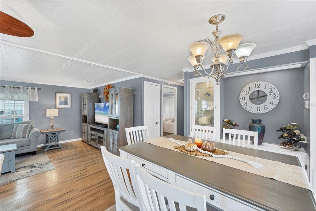 10303 Burnt Store Road, Unit 5 Punta Gorda, FL 33950 - Photo 17 of 49 a view of a dining room with furniture a chandelier and wooden floor