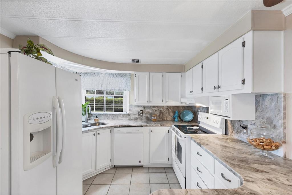 10303 Burnt Store Road, Unit 5 Punta Gorda, FL 33950 - Photo 18 of 49 a kitchen with a sink window and cabinets