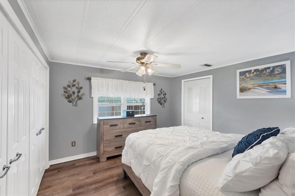 10303 Burnt Store Road, Unit 5 Punta Gorda, FL 33950 - Photo 29 of 49 a spacious bedroom with a large bed and a chandelier