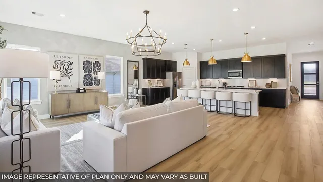 a living room with furniture a flat screen tv and kitchen view
